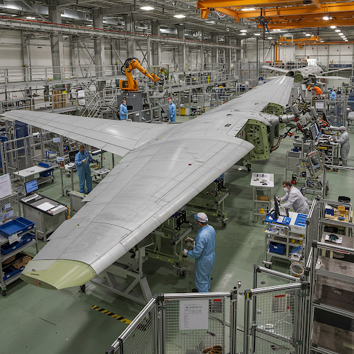 Aerospace technicians assembling large aircraft wing in factory